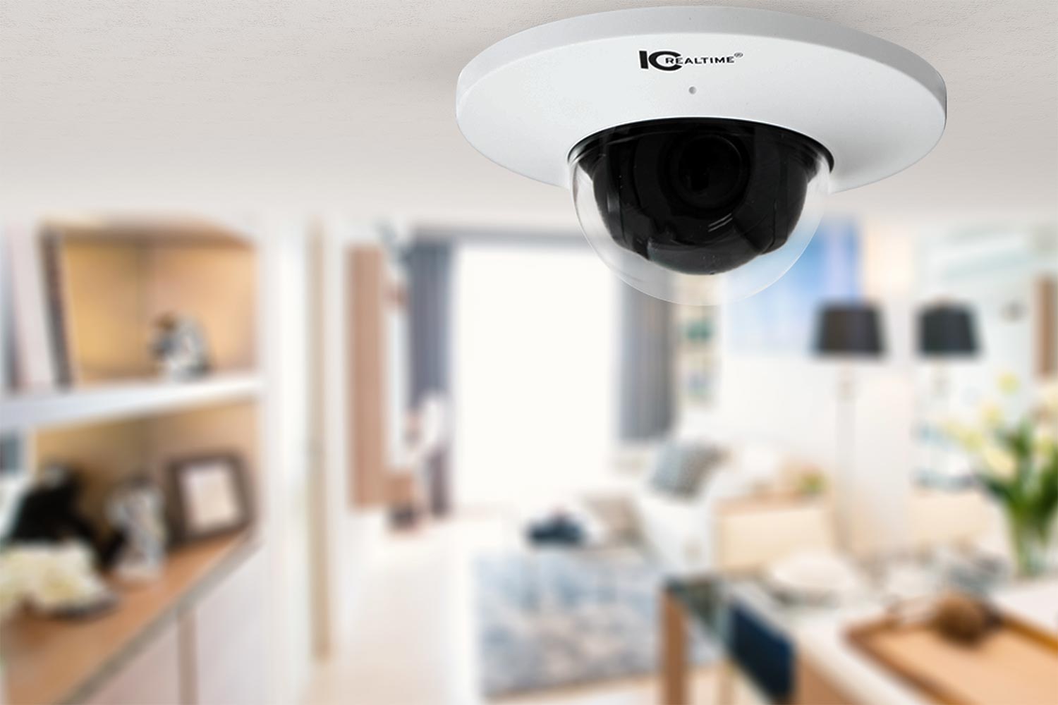 A ceiling-mounted dome surveillance camera with a blurred view of a modern living room in the background, highlighting smart home security.